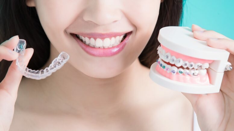 Woman Holding Invisalign and Braces